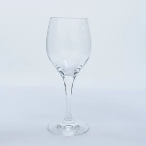 Clear wine glass with slender stem and round bowl on white background.