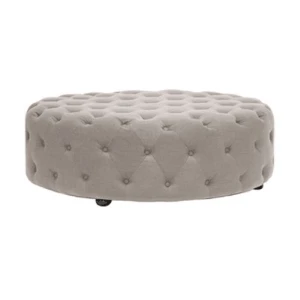 Round taupe tufted ottoman with button detailing, featuring a plush velvet-like fabric and low wooden legs.