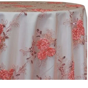 White tablecloth with coral-pink floral lace overlay, draped with soft pleats and elegant embroidered design.