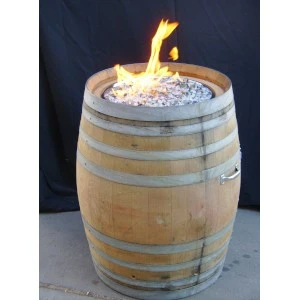 Wooden wine barrel fire pit with flickering flame and decorative glass rocks for rustic event decor.