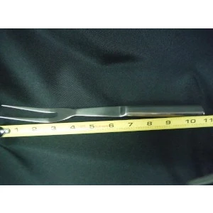 Stainless steel surgical instrument or medical tool resting on yellow measuring tape against dark background.