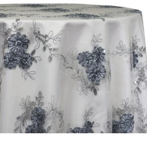White tablecloth with delicate blue-gray floral lace overlay creates an elegant, romantic textile for event.