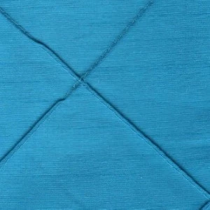 Turquoise blue fabric napkin folded into triangular shape with diagonal crease lines.