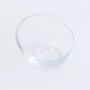 Clear glass serving bowl with smooth, translucent sides and round shape on white background.