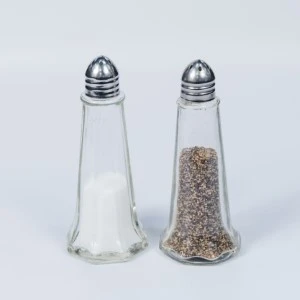 Glass salt and pepper shakers with metal screw-top lids, one filled with white salt, the other with dark pepper.
