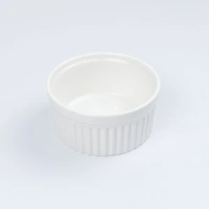 White ceramic ramekin with fluted sides, smooth glazed finish and round shape for baking or serving.