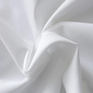Soft white fabric with elegant draped folds and smooth, billowing texture for event linens.