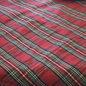 Classic holiday plaid fabric swatch in red, green, and black tartan pattern for event rental.